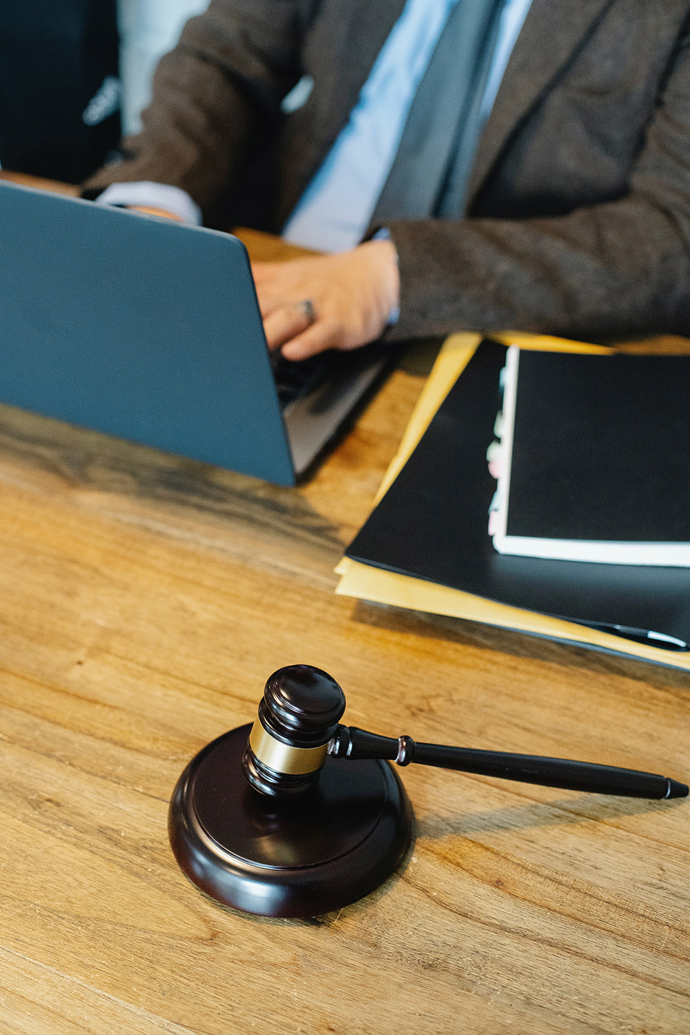 A Kelley Cawthorne team member types on their laptop next to a gavel.